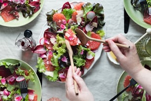 a table topped with plates of salad and utensils