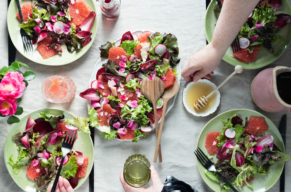una mesa cubierta con platos de ensalada y platos de fruta