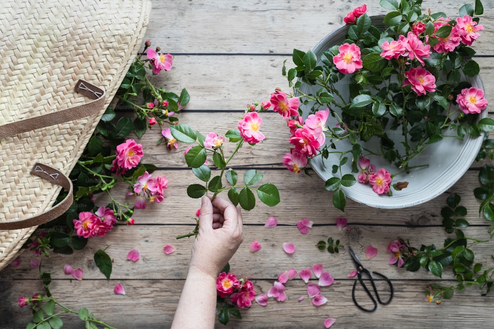 a person is arranging flowers on a wooden table