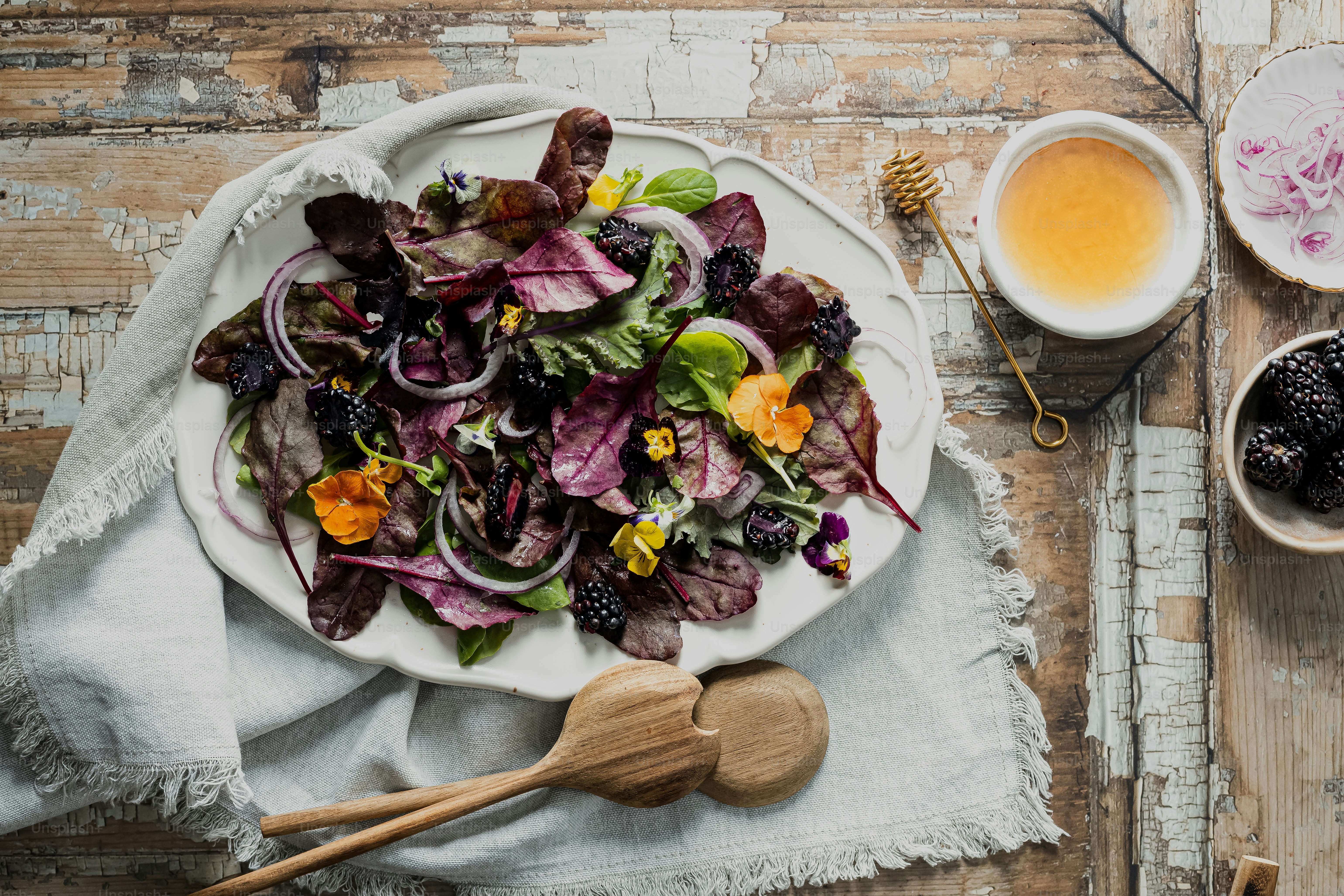 Foto zum Thema Ein weißer Teller mit einem Salat neben einer Tasse Tee ...