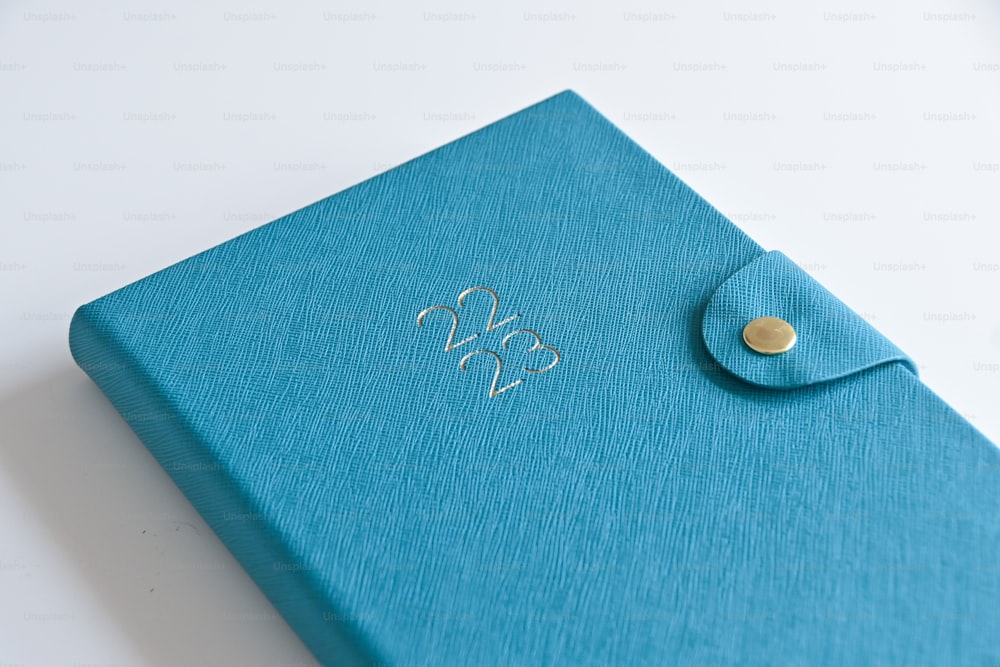 a close up of a blue notebook with a button