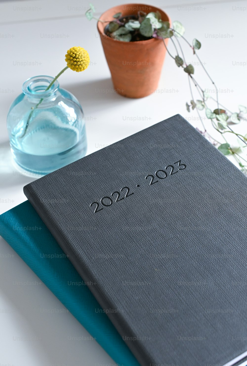 a book sitting on top of a table next to a vase of flowers