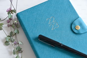 a pen sitting on top of a blue notebook