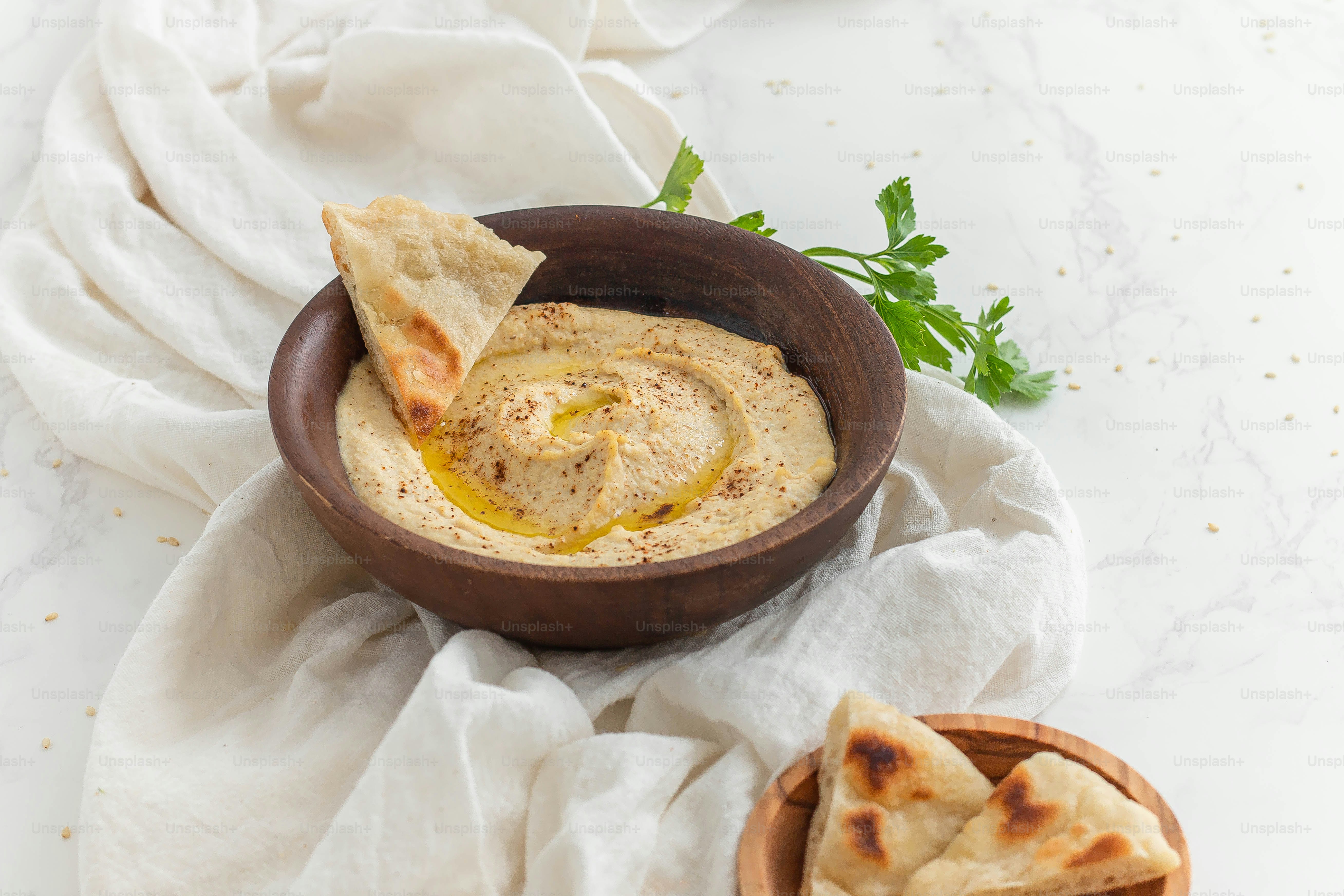 A bowl of hummus and pita chips on a table photo Food Image on Unsplash