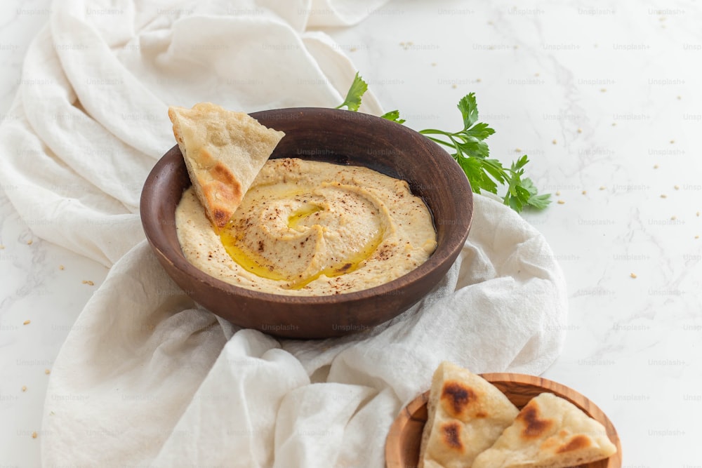 a bowl of hummus and pita chips on a table