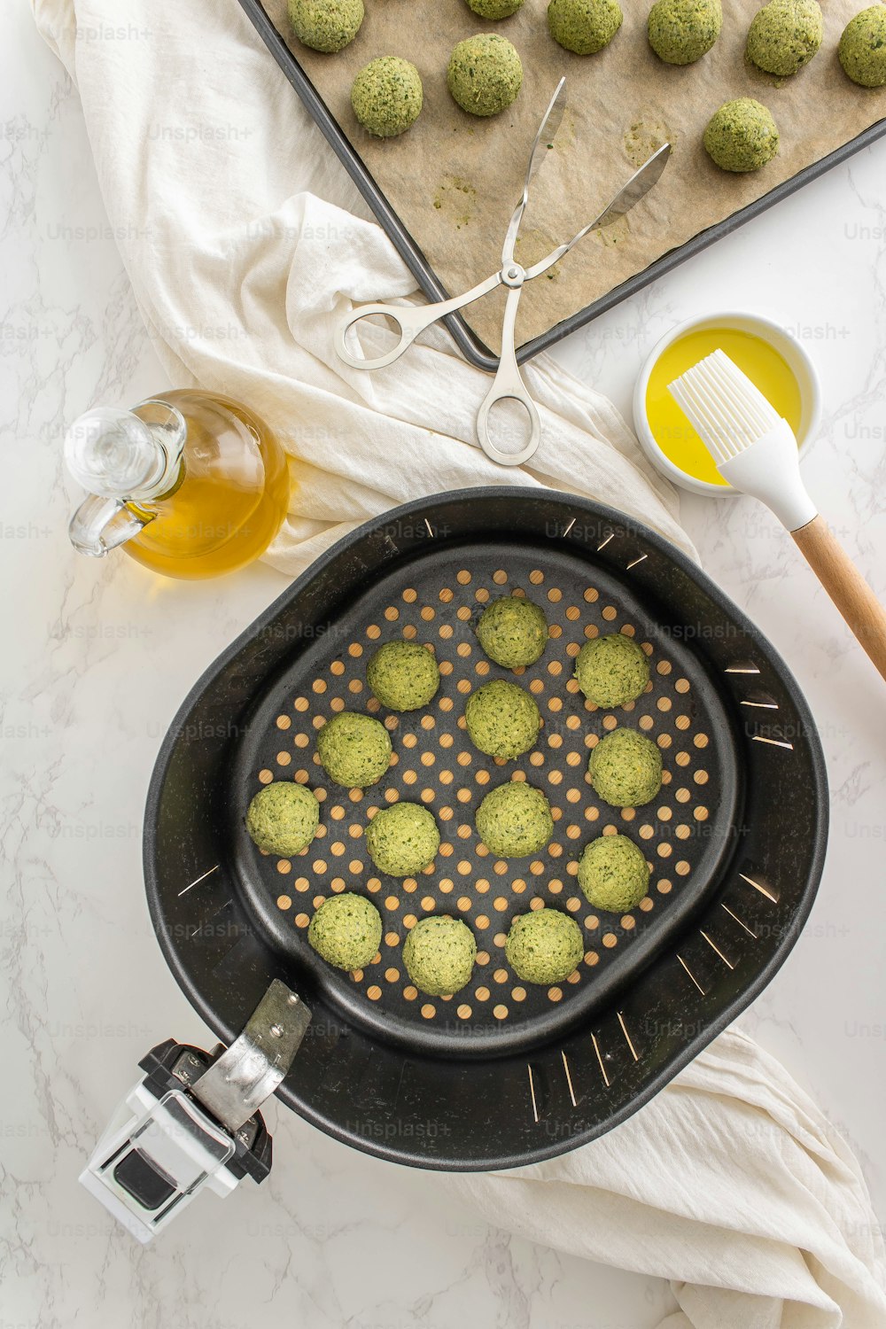 a pan filled with green cookies next to a cookie sheet