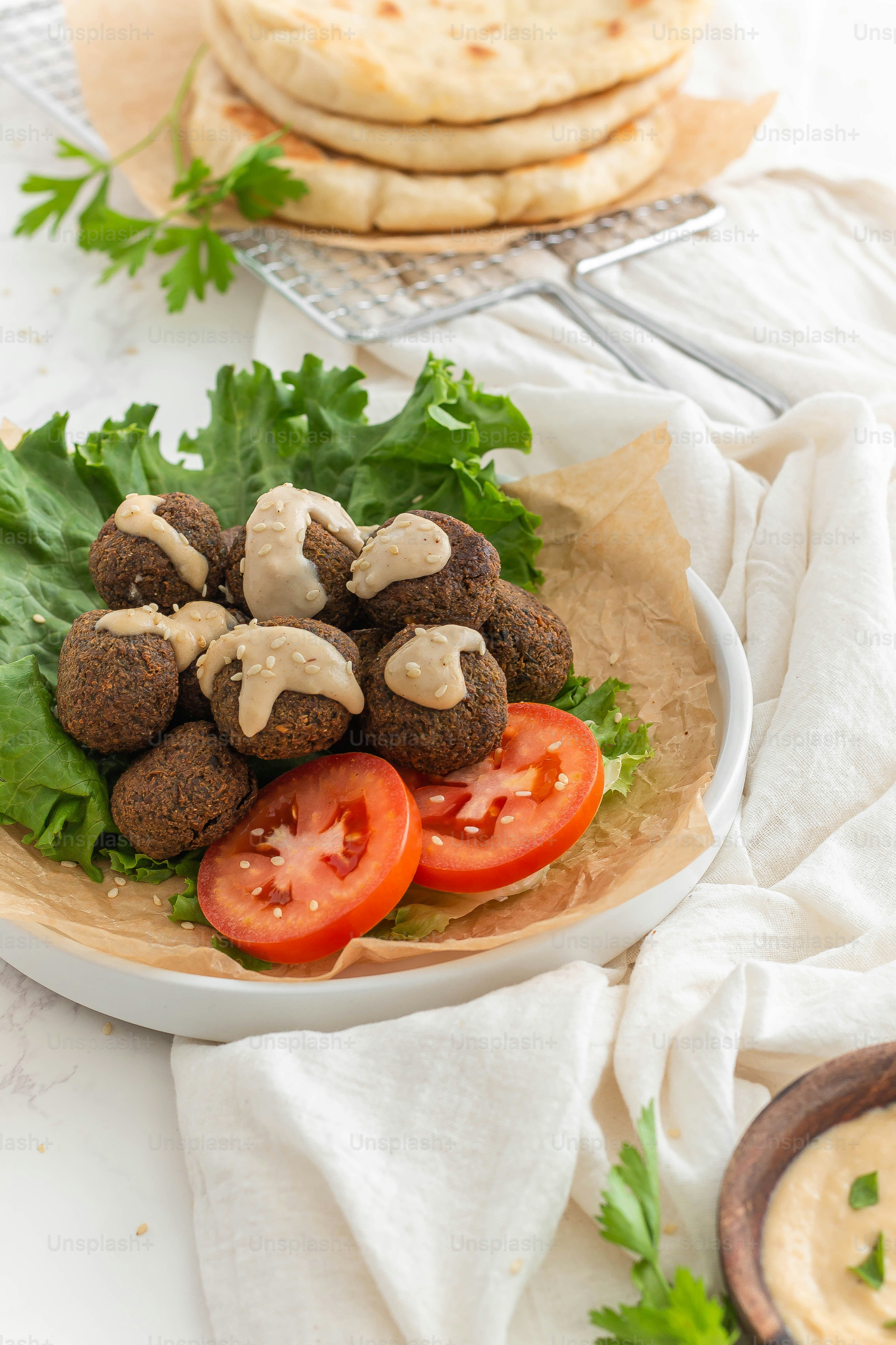 a plate of falafel and pita bread on a table