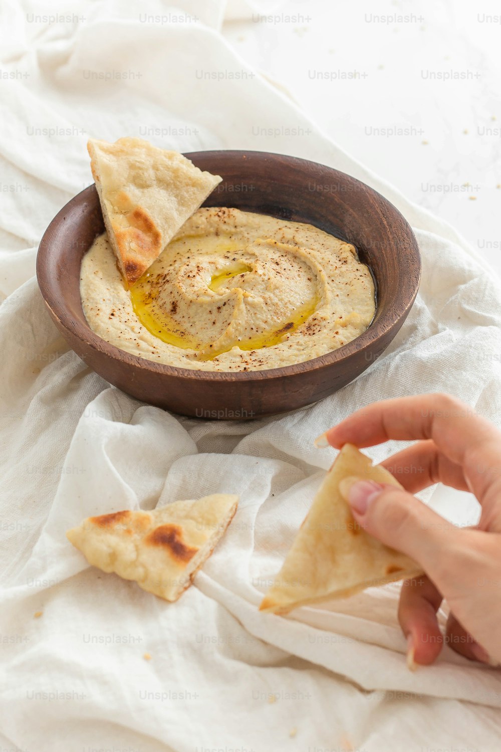 una ciotola di hummus e patatine pita su un tavolo