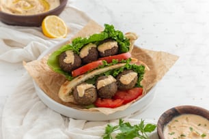 a meatball sandwich with lettuce and tomatoes