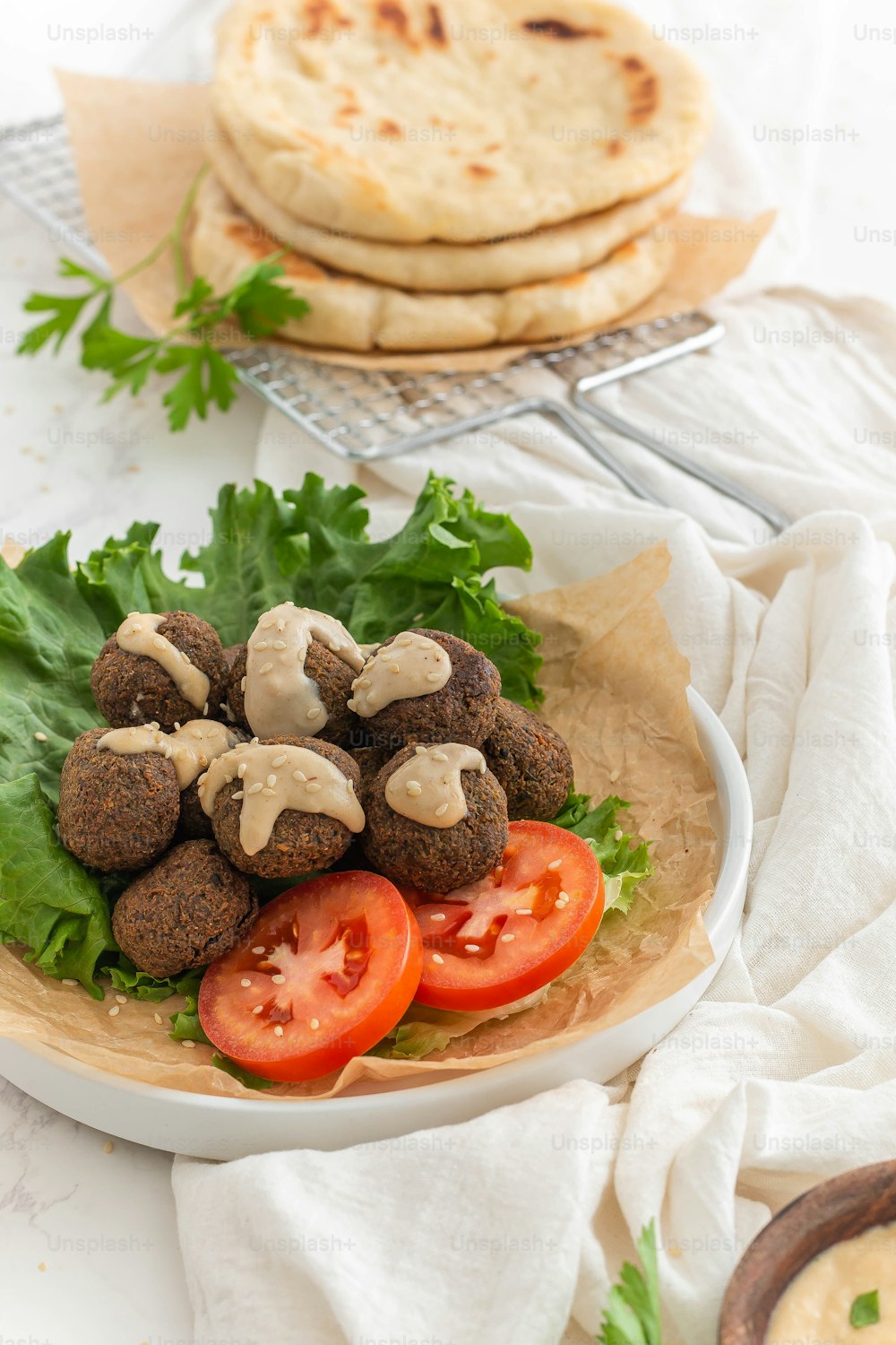 a plate of falafel and pita bread on a table