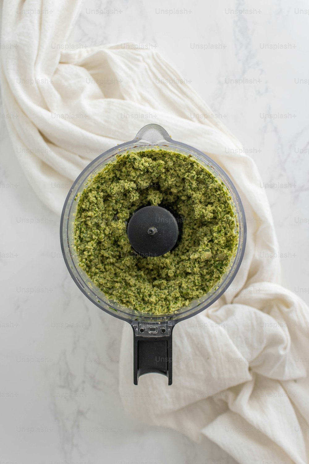 a food processor filled with pesto on top of a table