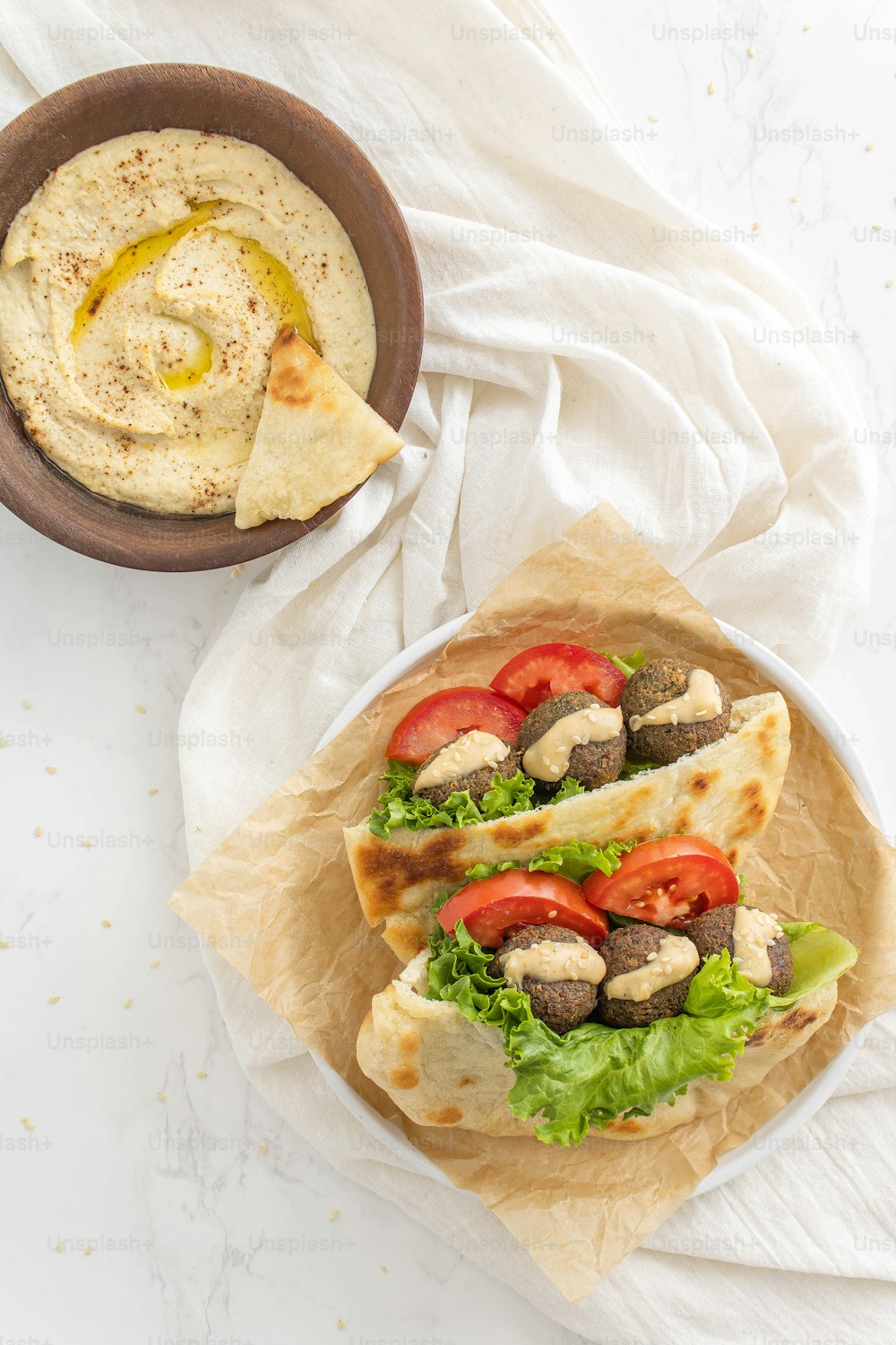 a plate of food with pita bread and a bowl of hummus
