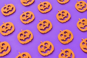 a group of pumpkin shaped cookies sitting on top of a purple surface