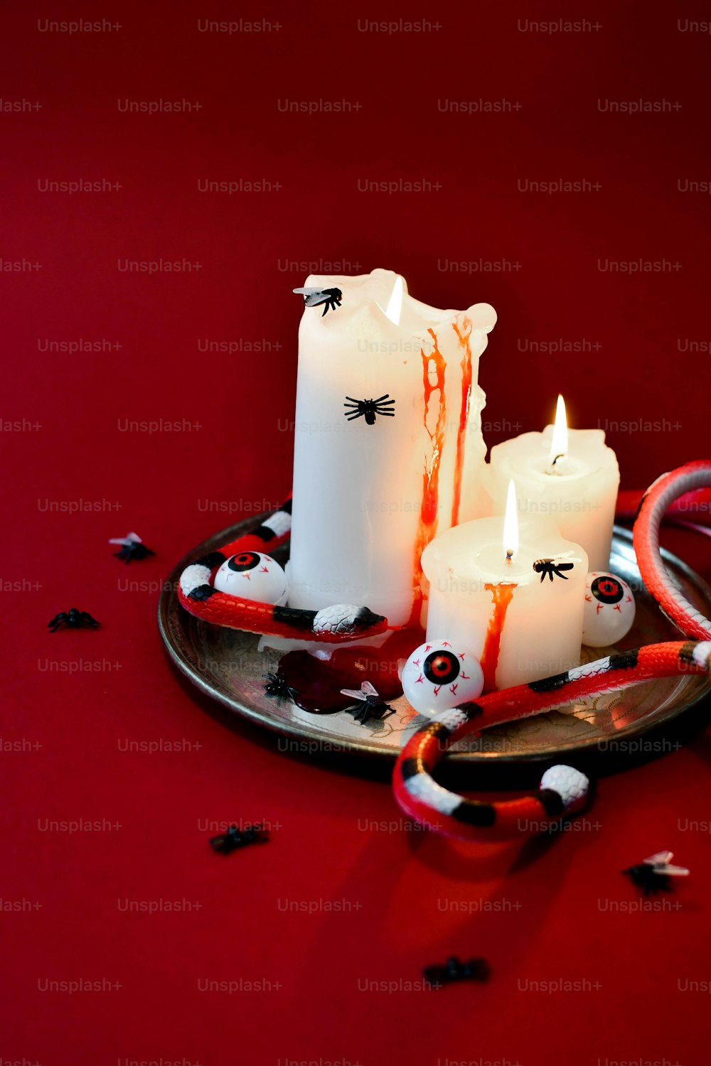 a couple of white candles sitting on top of a plate