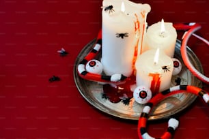 ein Teller mit Kerzen und Halloween-Dekorationen darauf