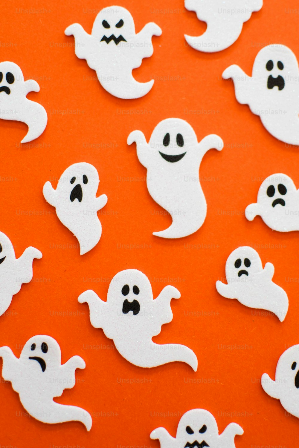 a group of ghost stickers on an orange background