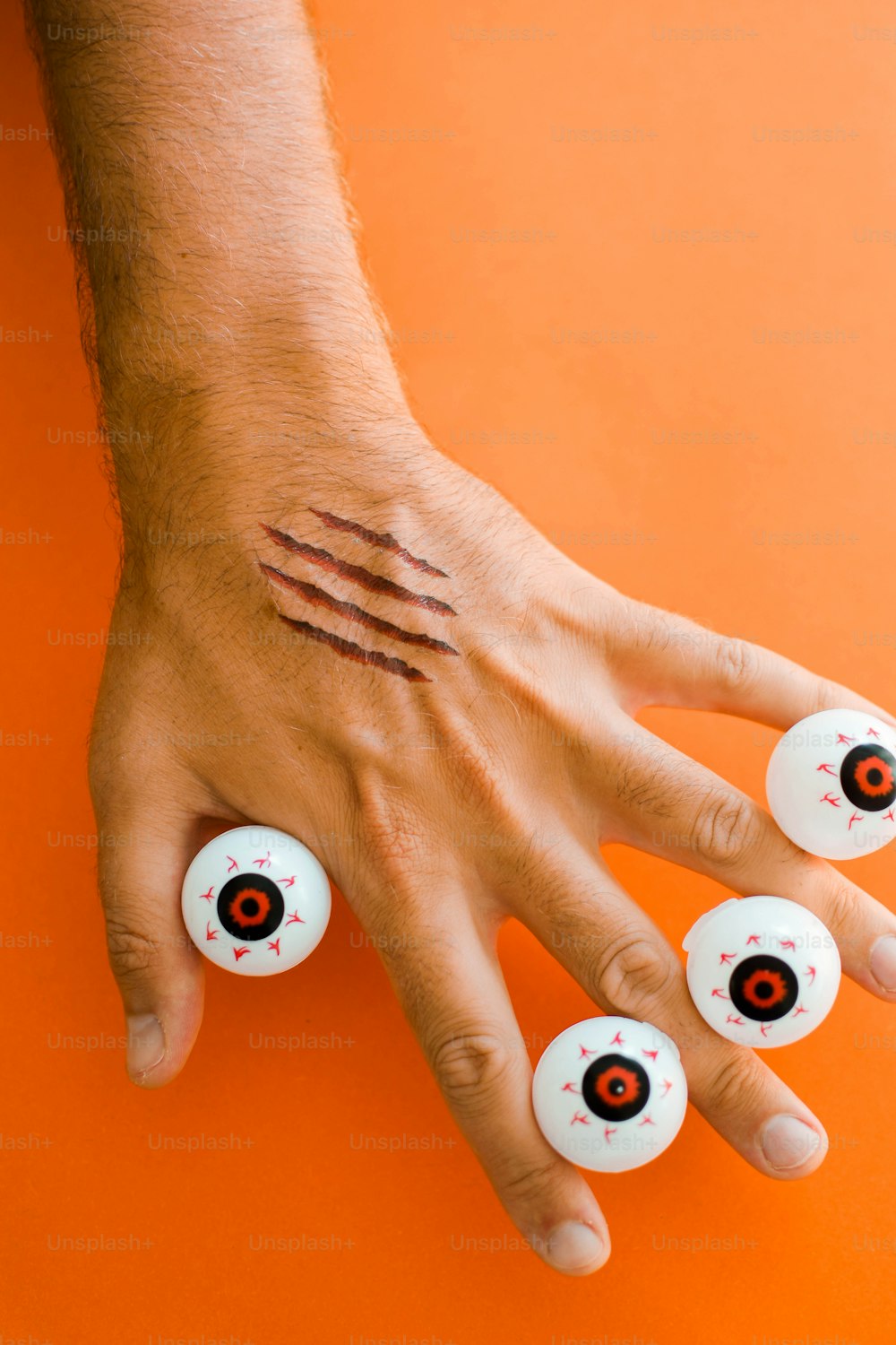 a person's hand with three fake eyeballs on it