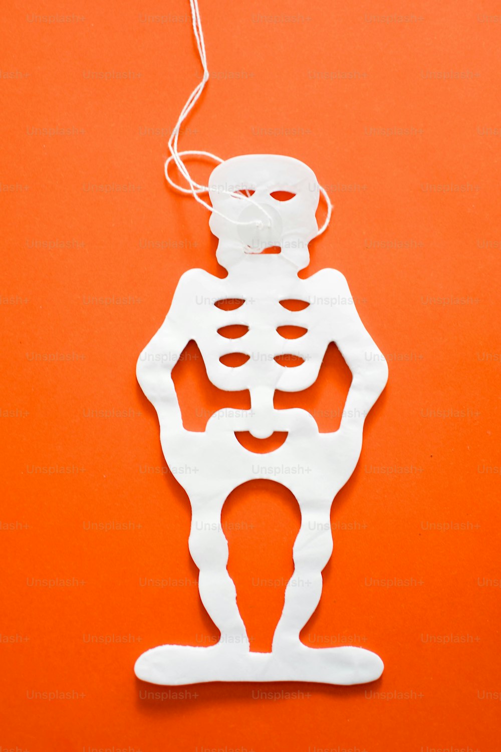 a paper cut out of a skeleton on an orange background