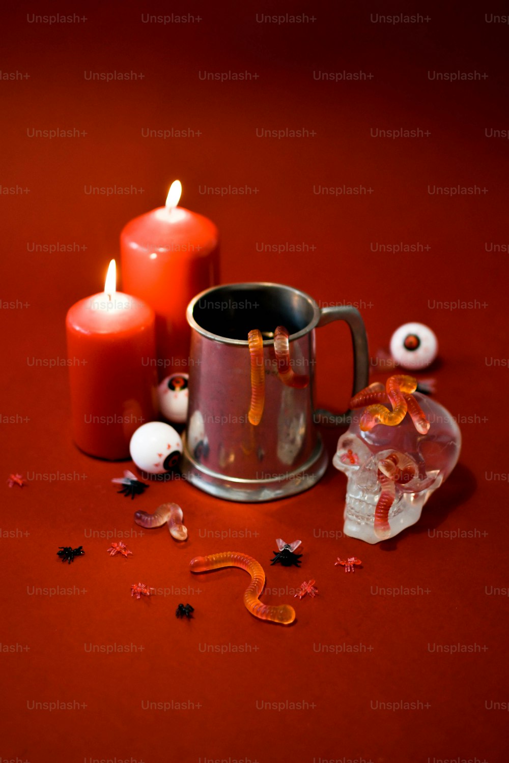 a red table topped with two candles and a cup
