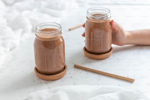 a person holding a jar of chocolate on top of a table