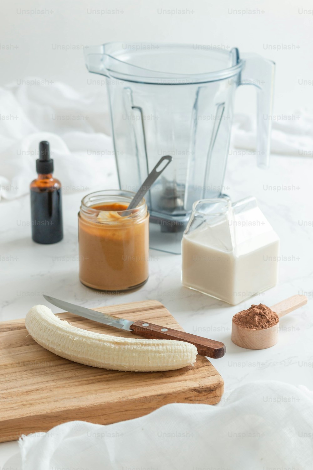 a banana sitting on a cutting board next to a blender