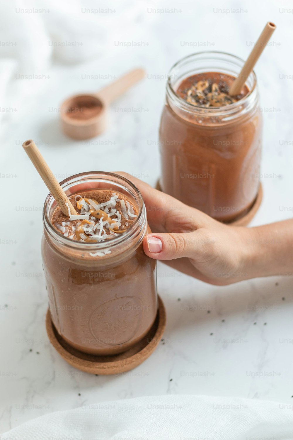 a person holding a spoon in a jar of chocolate pudding