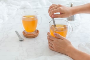 a person holding a spoon in a cup of tea