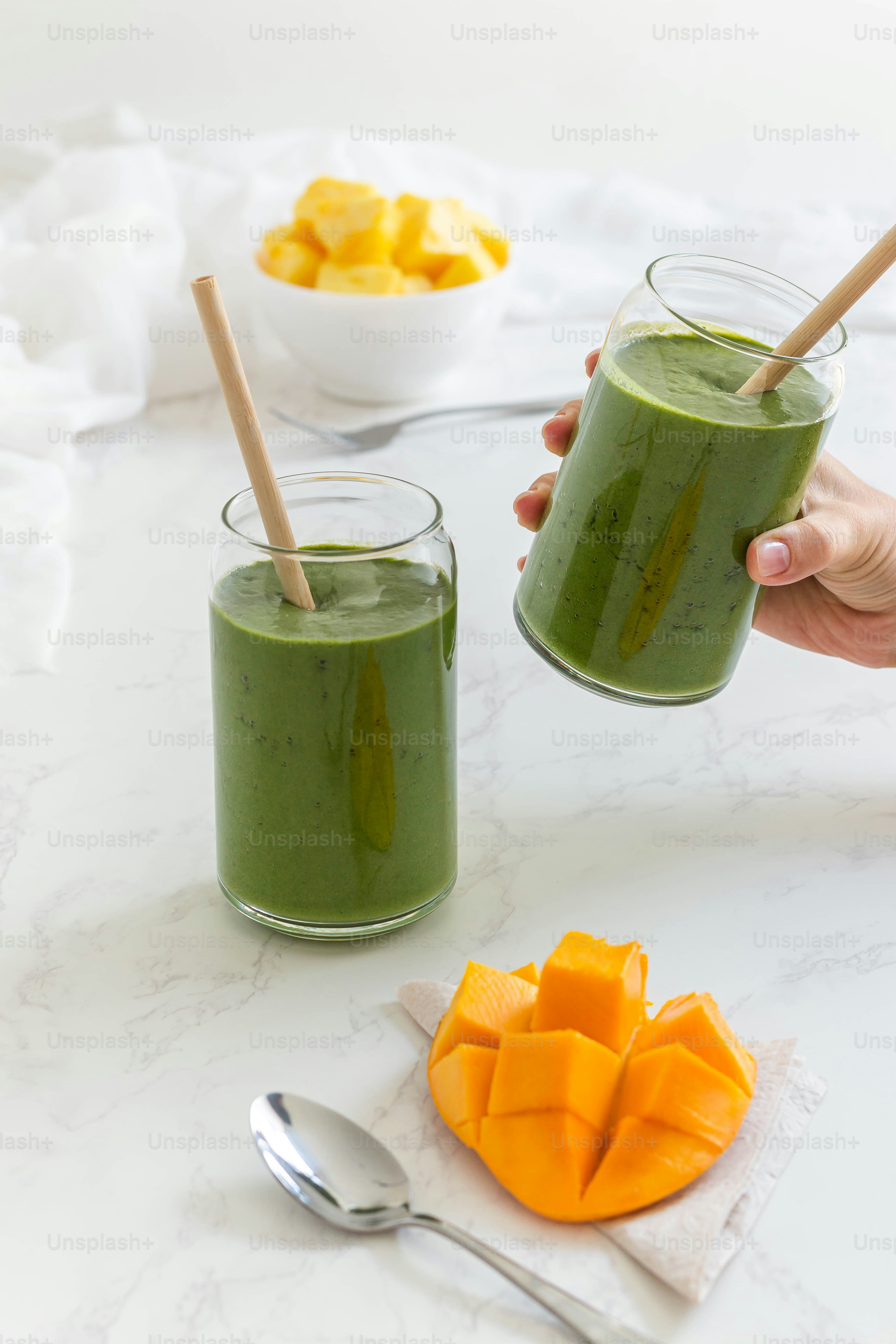 uma pessoa segurando um copo de smoothie verde