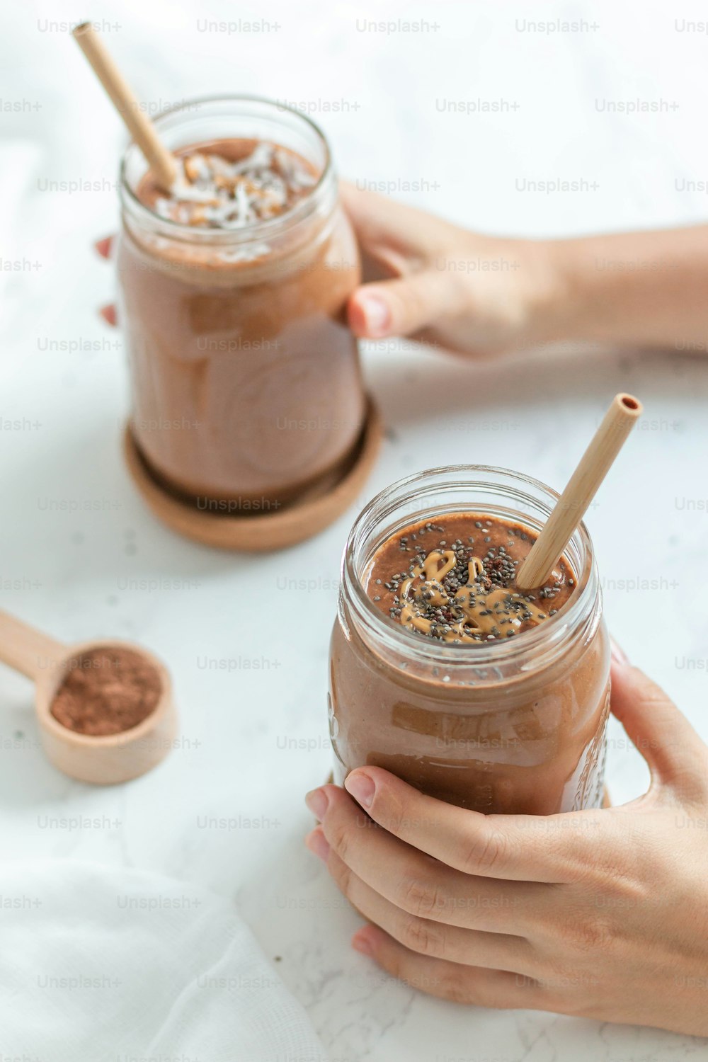 a person holding a jar of chocolate smoothie