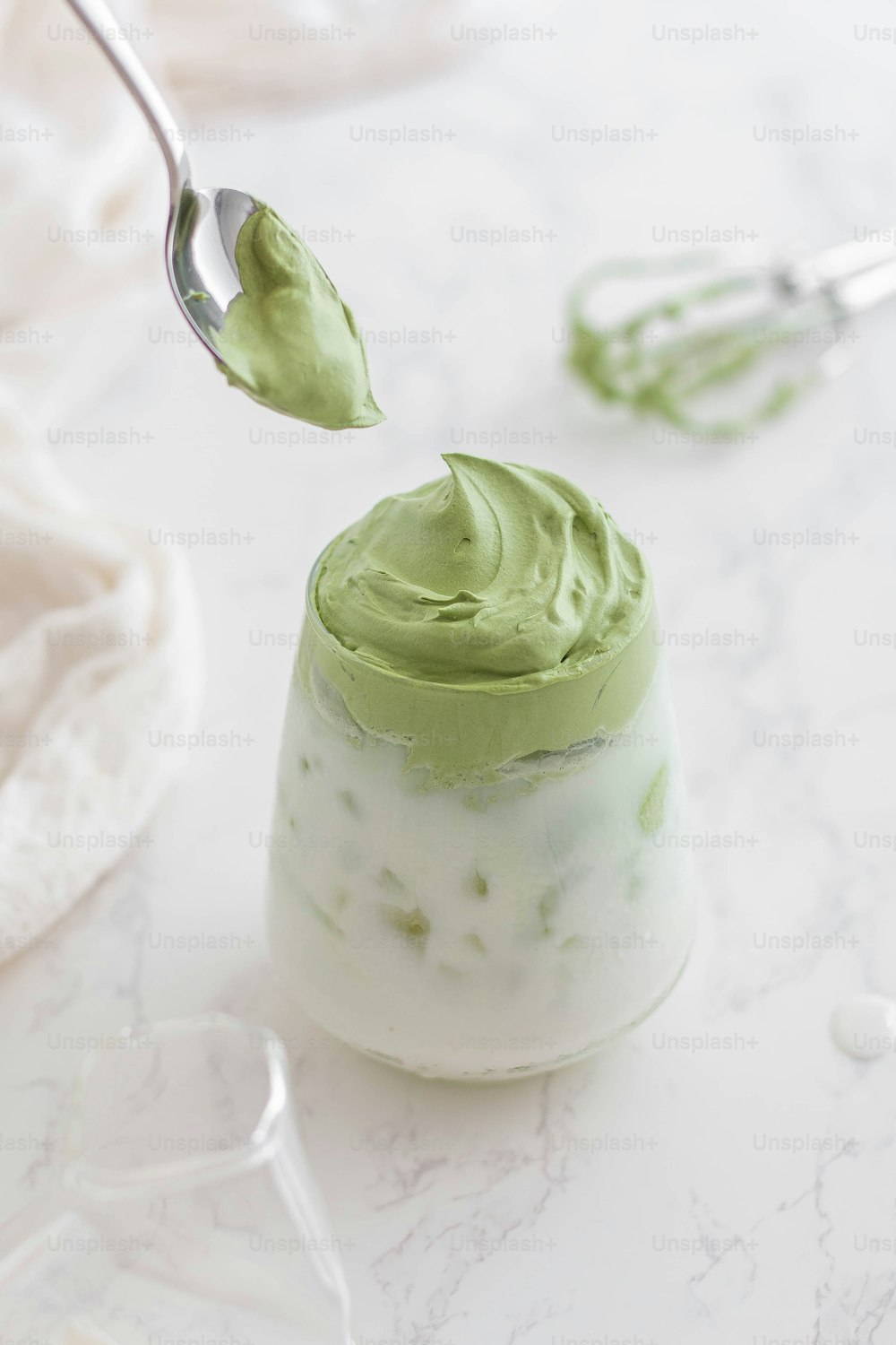 a spoon with some green cream on it