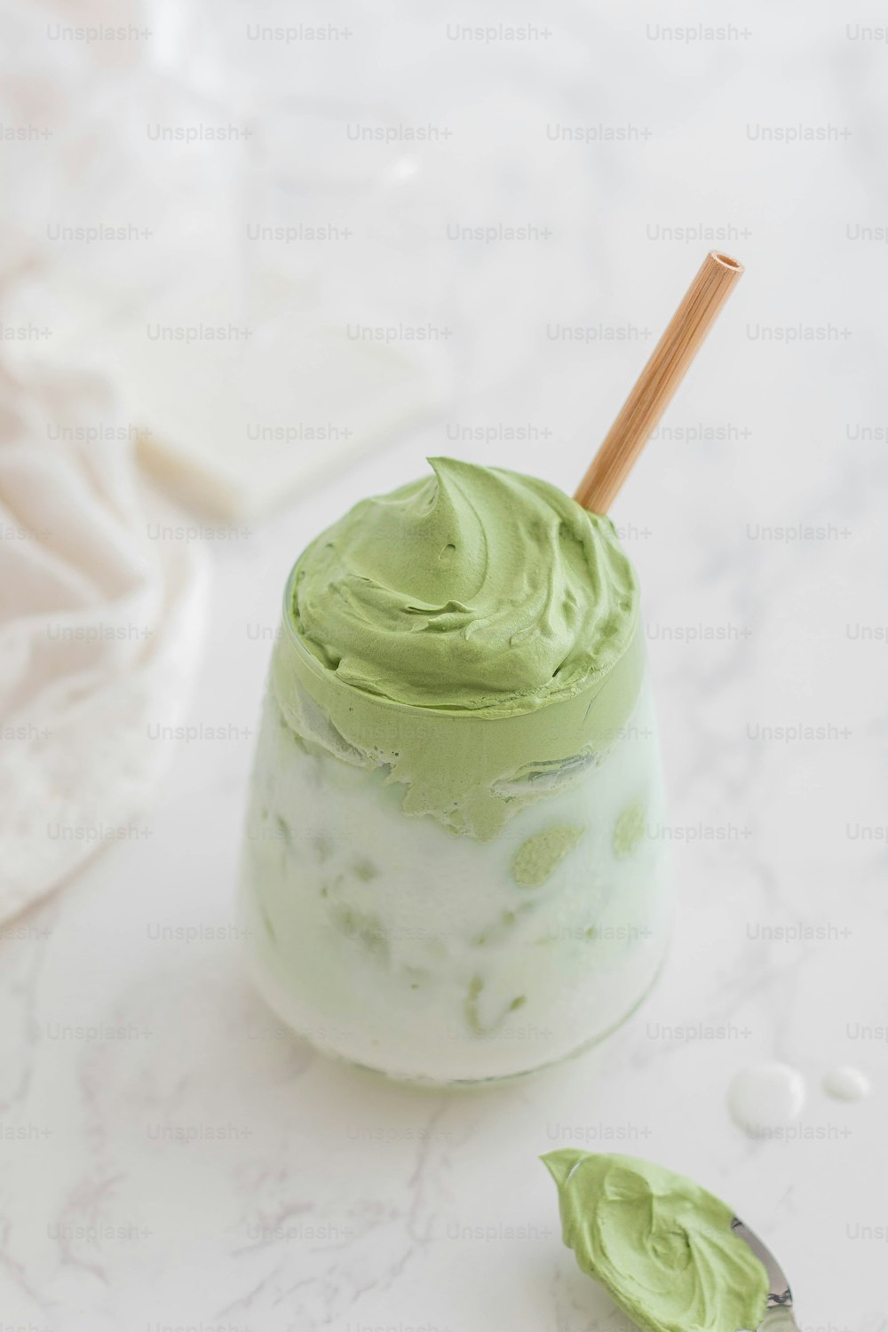 a small jar of green whipped cream with a wooden spoon