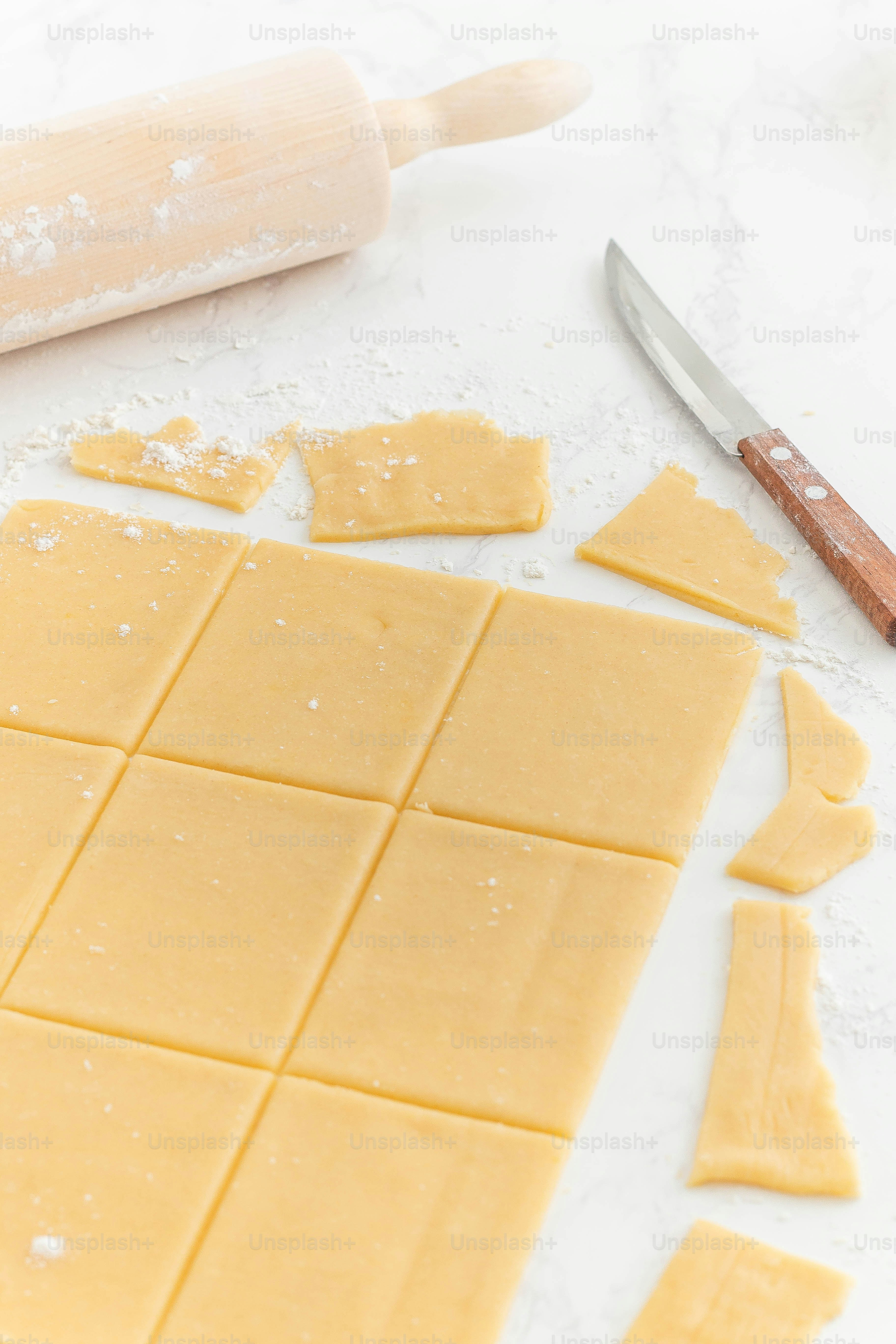 una tabla de cortar con masa y un rodillo