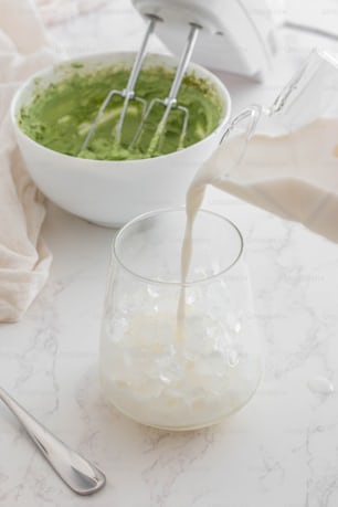 a bowl of green liquid being poured into a glass