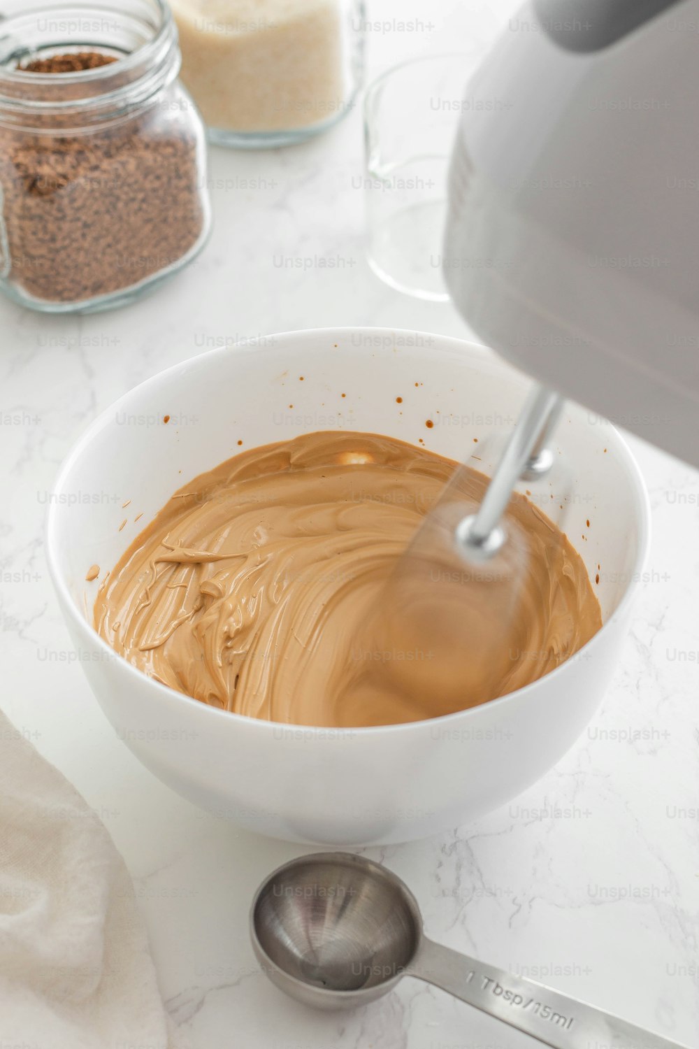 a bowl of peanut butter next to a mixer