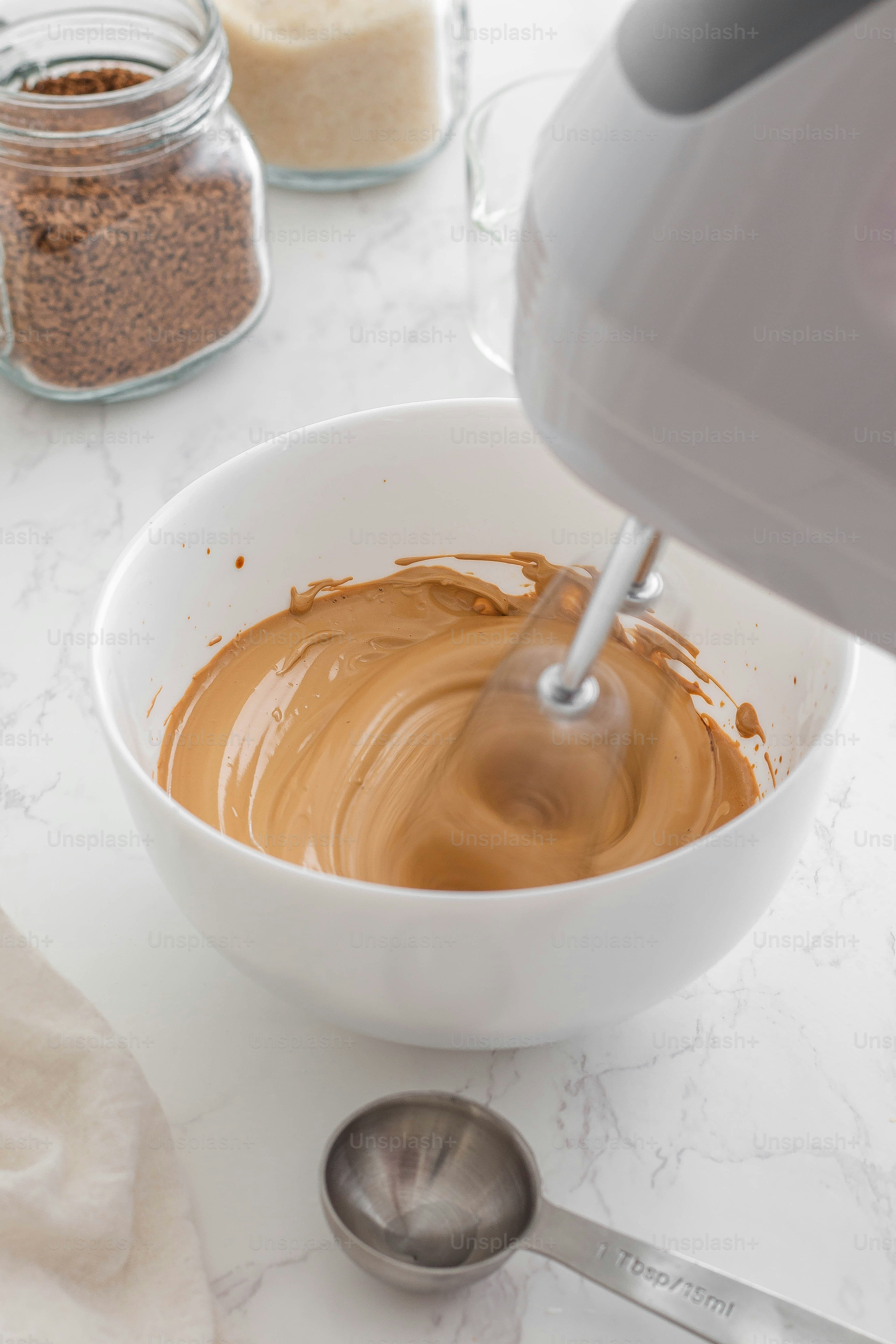 una ciotola di burro di arachidi accanto a un mixer