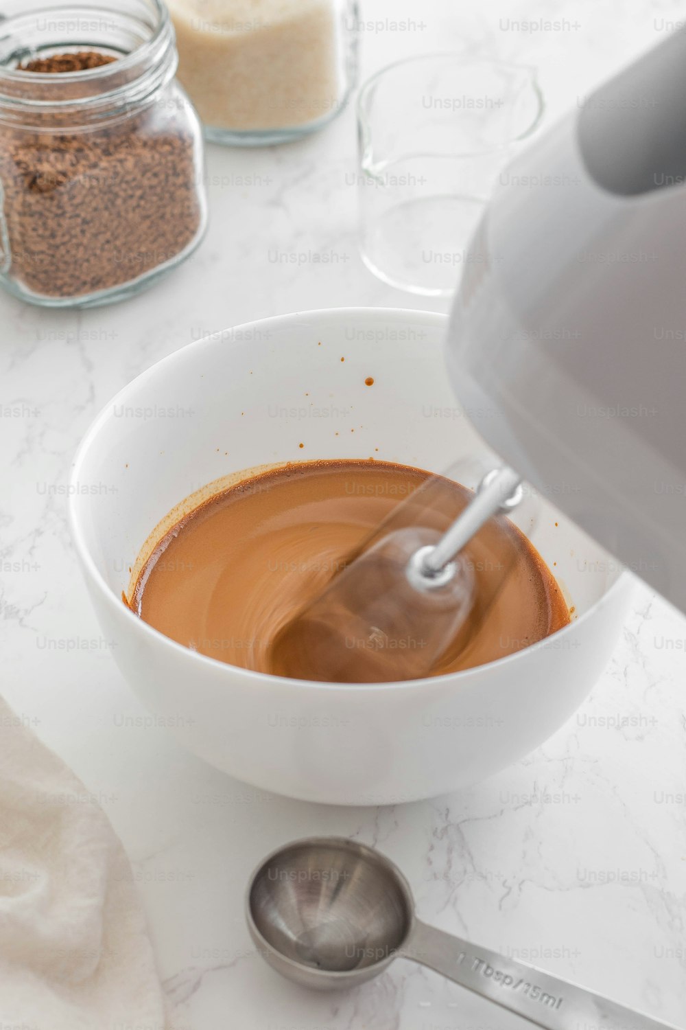 a white bowl filled with liquid next to a blender