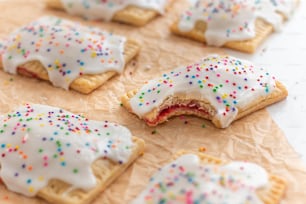 a close up of a pastry with white frosting and sprinkles