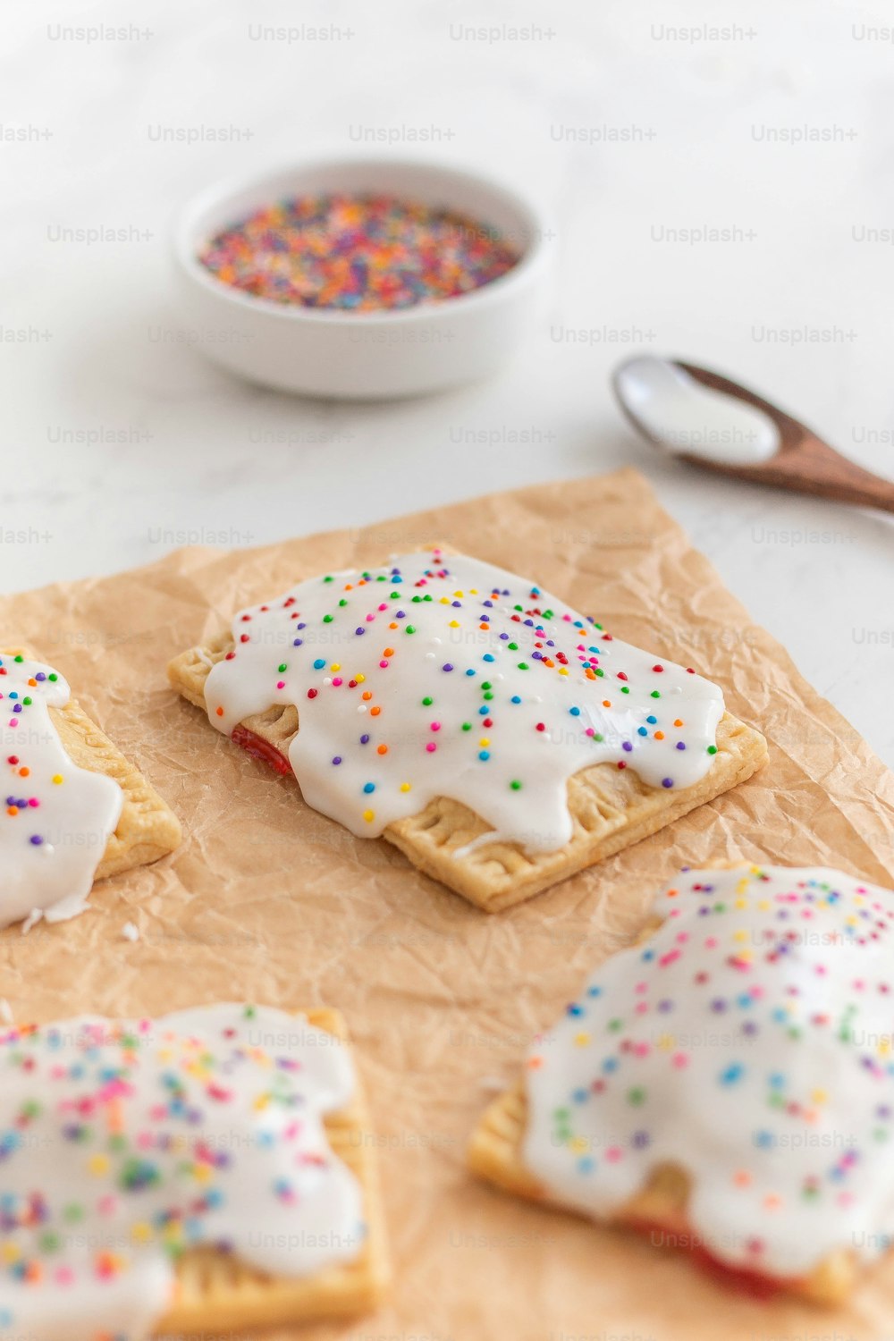 a table topped with cookies covered in frosting and sprinkles