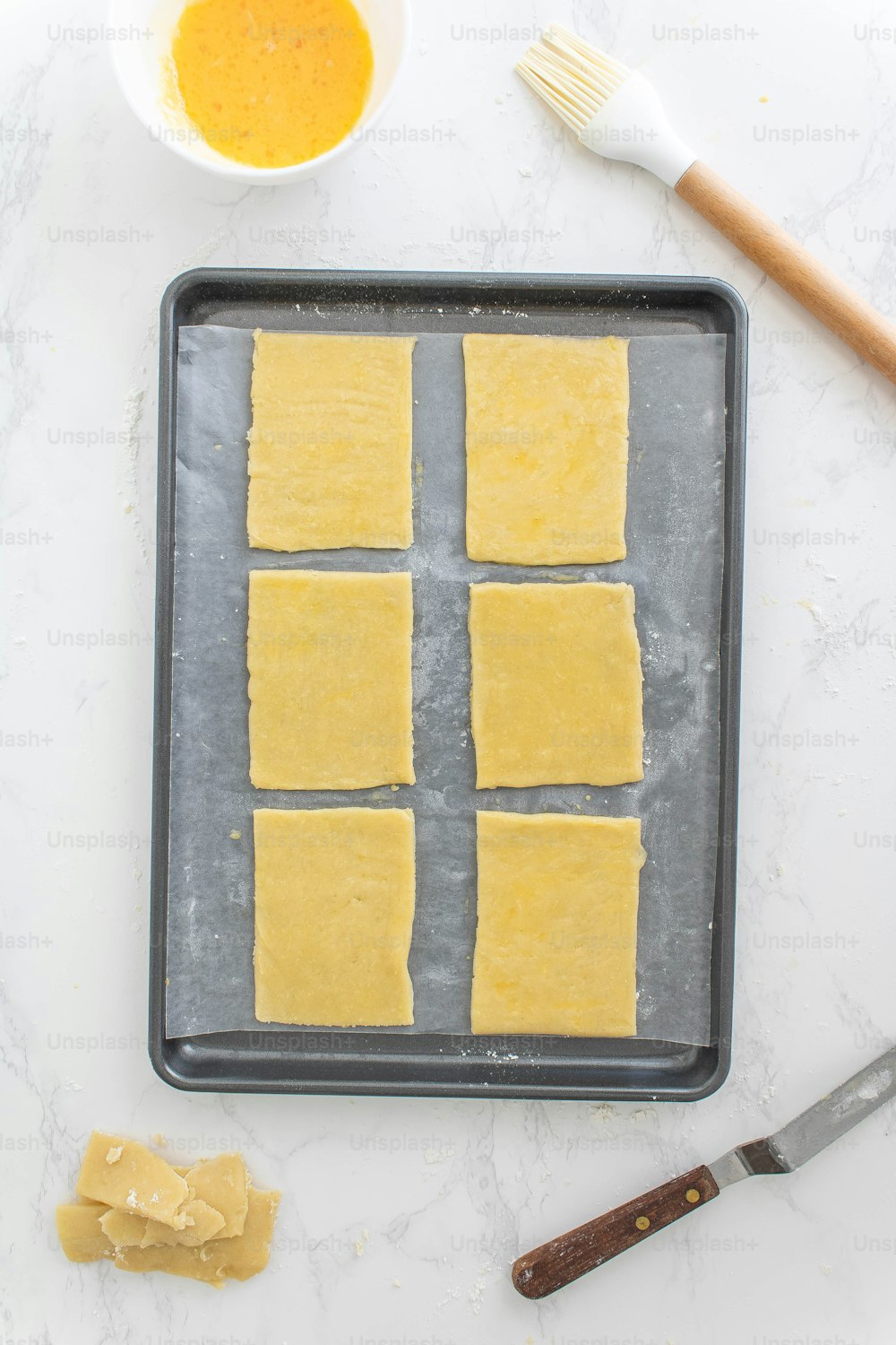 une casserole remplie de carrés de nourriture à côté d’un bol de moutarde