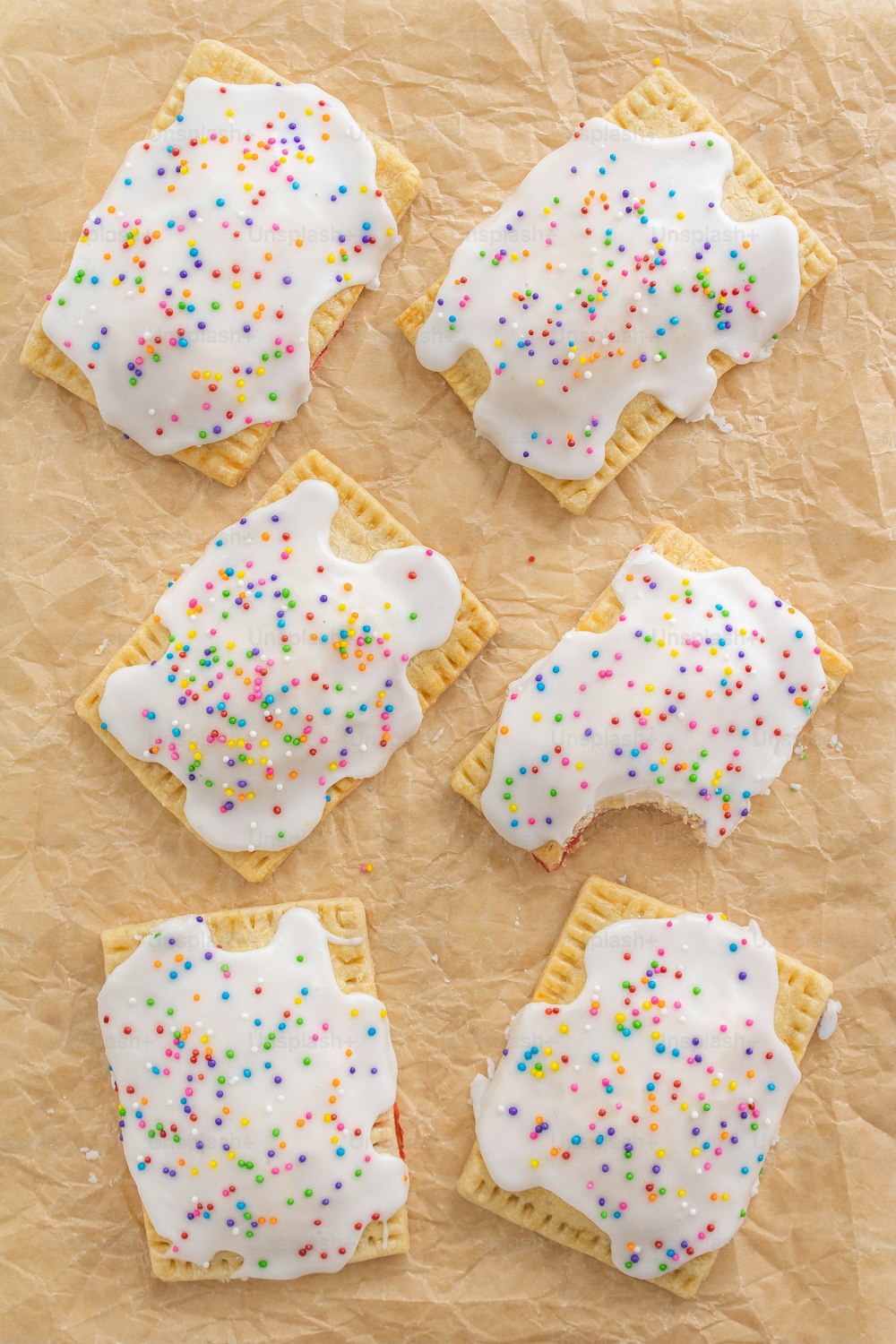 six decorated cookies on a piece of parchment paper