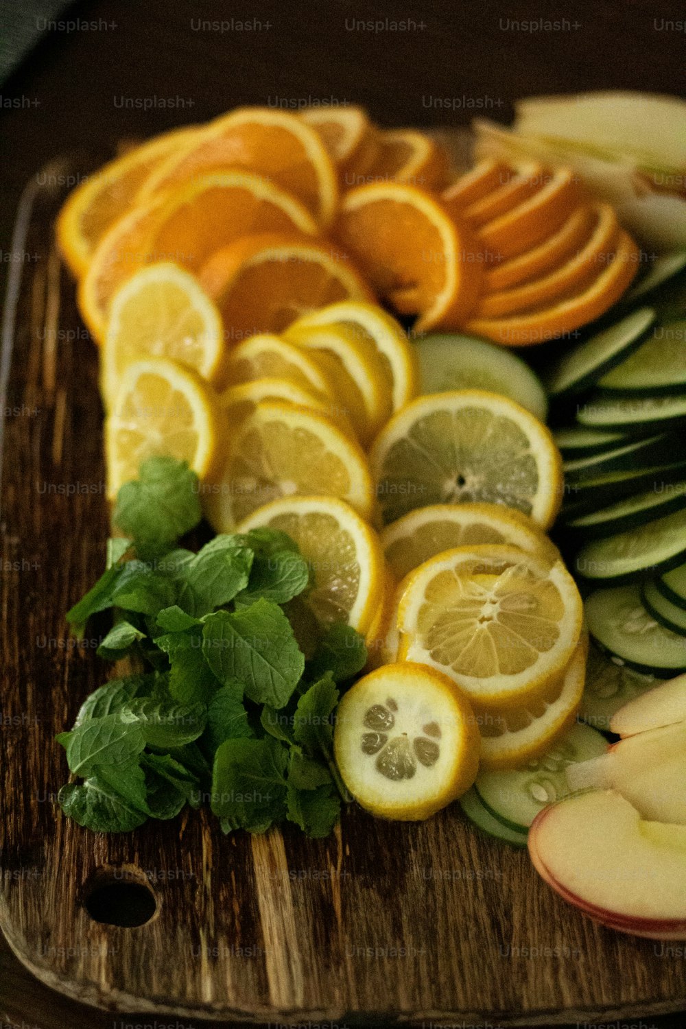 a cutting board topped with sliced oranges and cucumbers