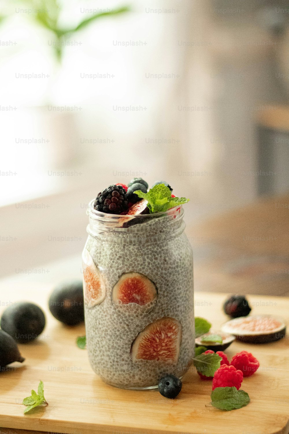 a jar of chia pudding topped with berries and mint