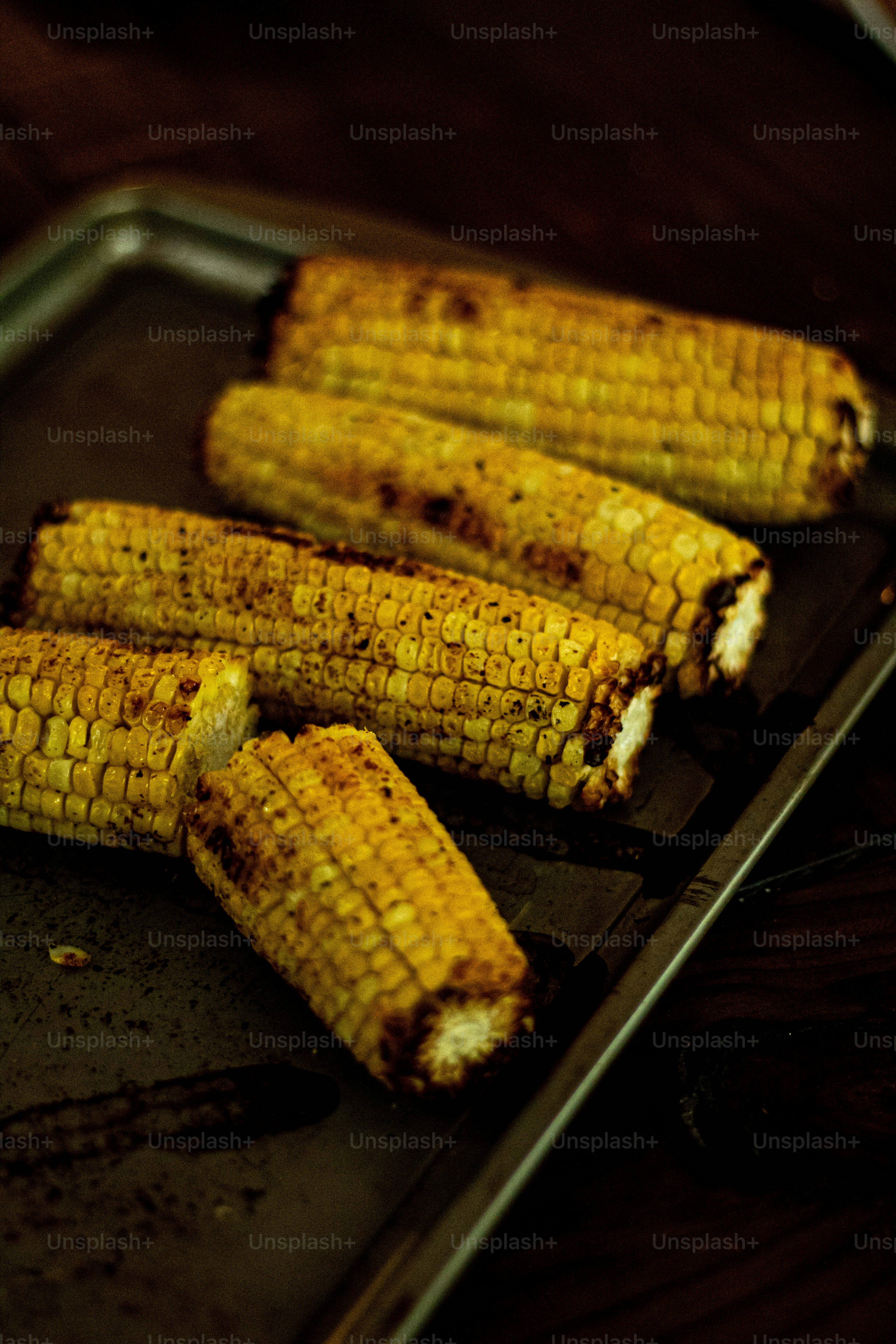 grilled corn on the cob on a baking sheet