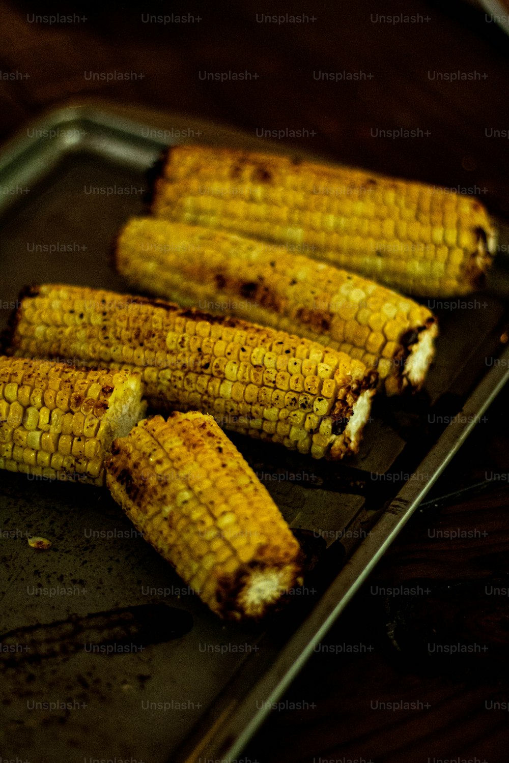 grilled corn on the cob on a baking sheet
