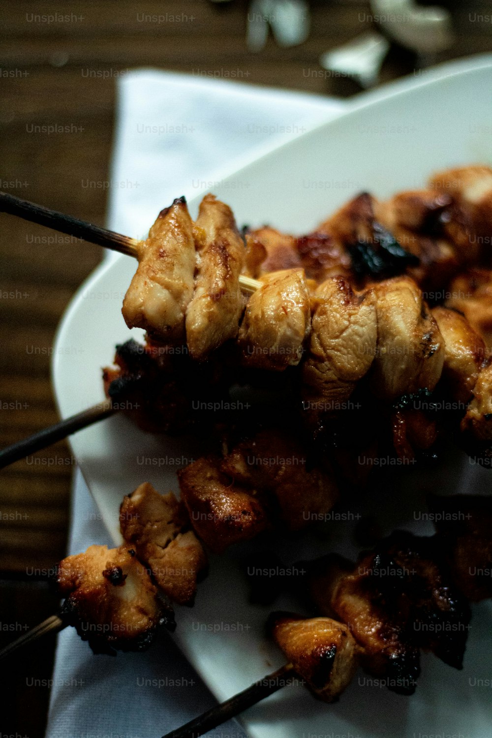 a white plate topped with meat and skewers