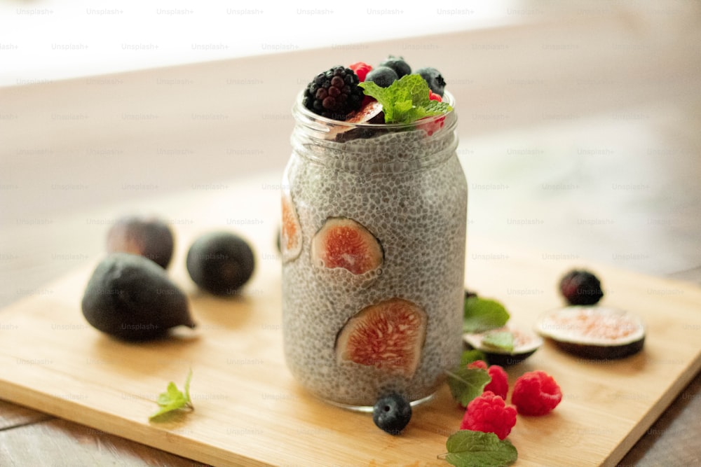 a jar of chia seed pudding with berries and mint