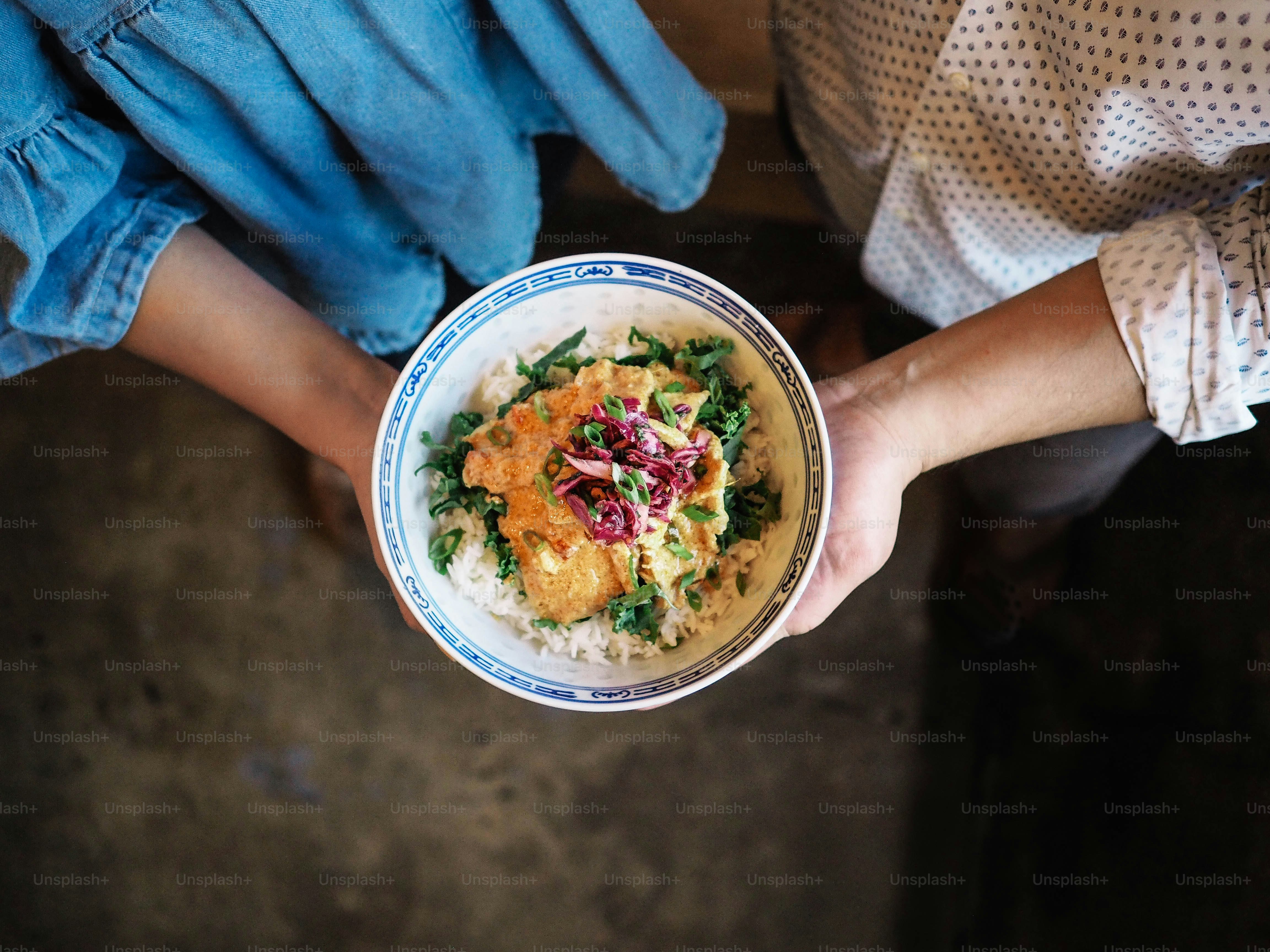 a person holding a bowl of food in their hands