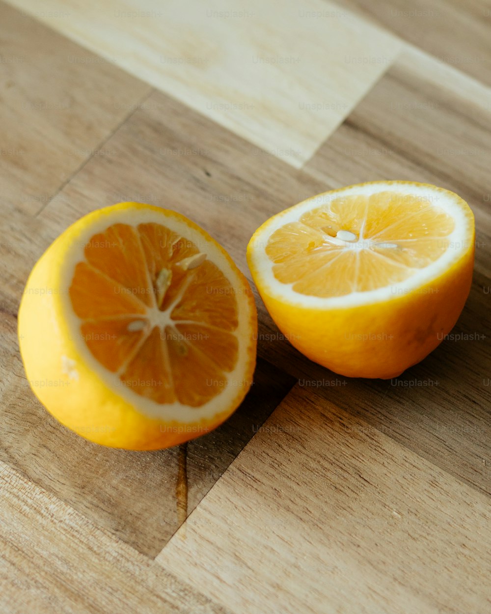 two oranges cut in half on a cutting board