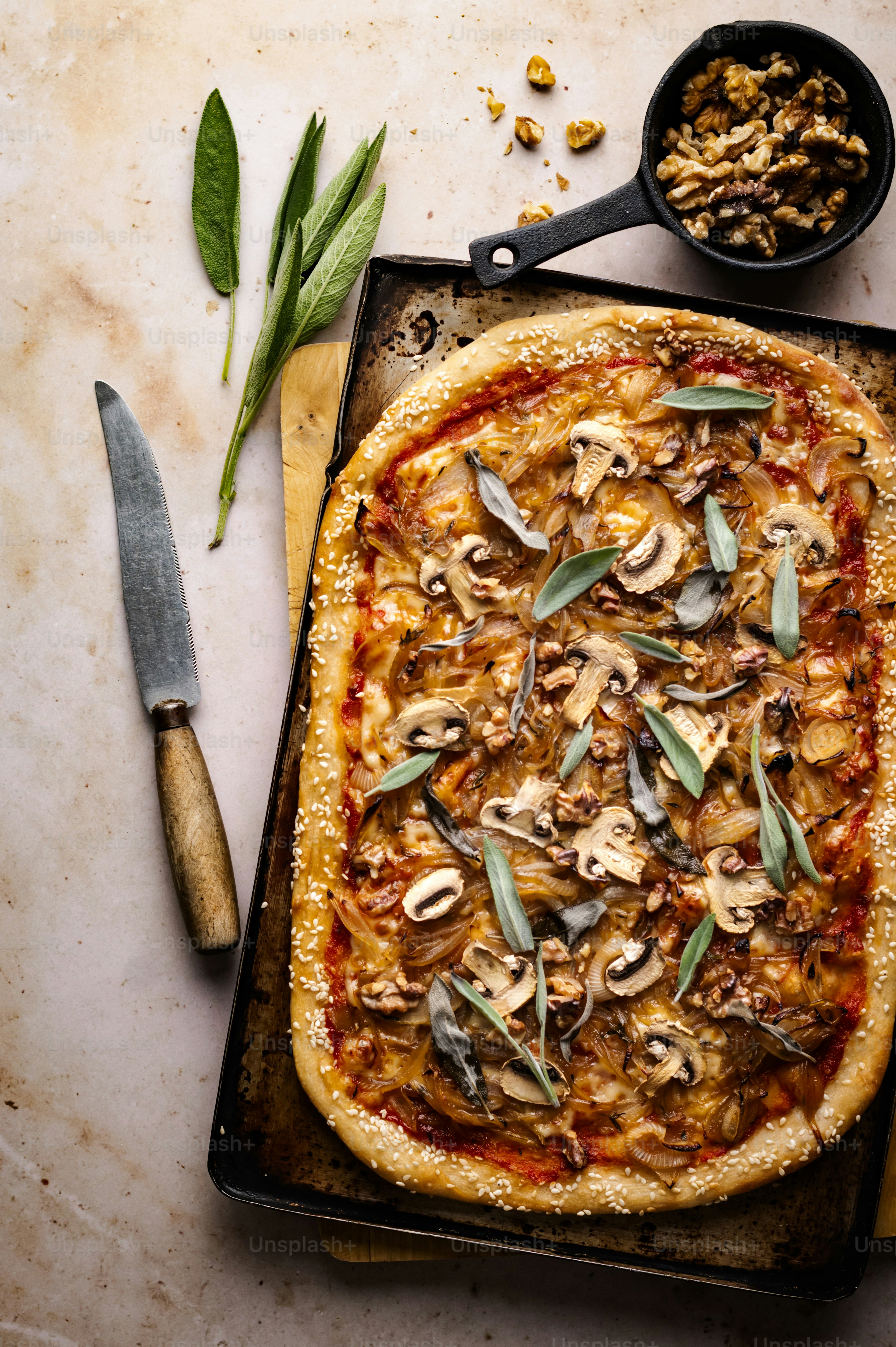 una pizza seduta sopra una teglia accanto a un coltello