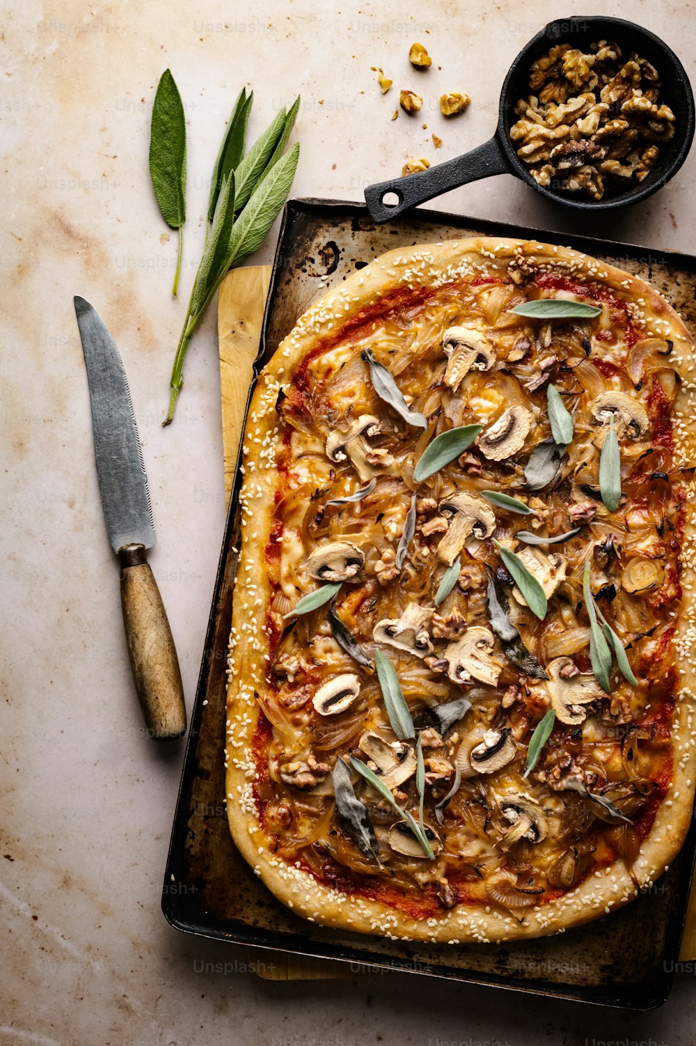 a pizza sitting on top of a pan next to a knife